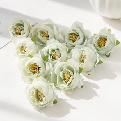A cluster of delicate pale green silk peony flowers with soft layered petals and golden yellow centers for decor