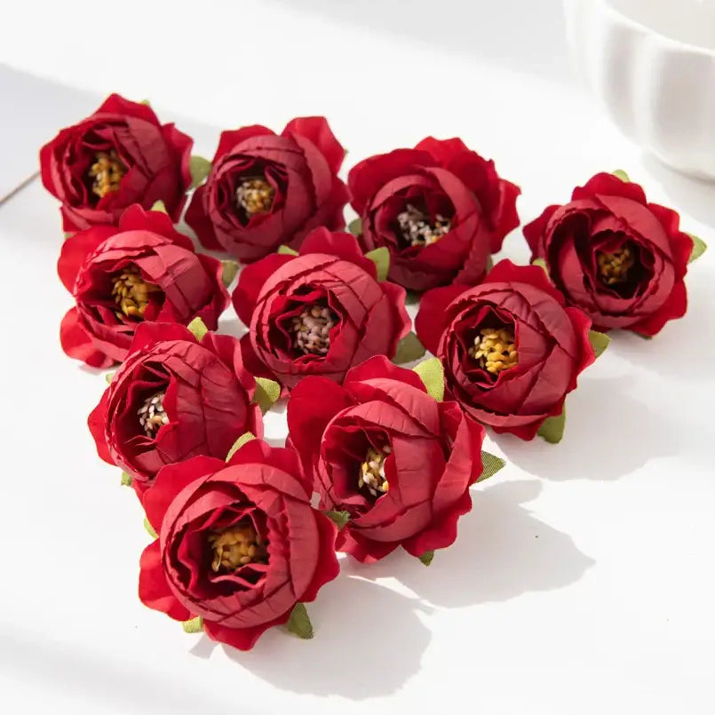 A cluster of deep red silk peony flowers with textured petals and green stems for wedding and home decor