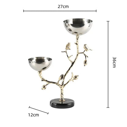 A sleek two-bowl metal snack bowl with gold bird branch design on black marble base for dining room use