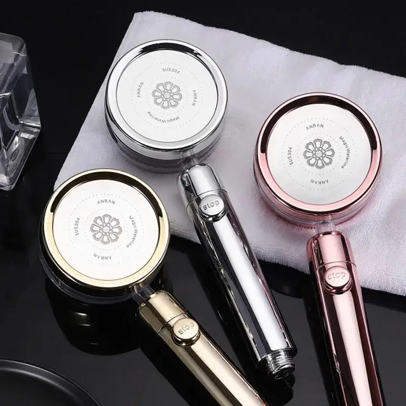 Three modern shower heads in silver, rose gold, and gold with floral emblem matching handles for double panel turbo use