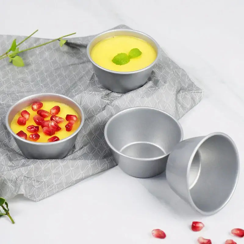 Set of three silver carbon steel mini round cake molds by decorbites with yellow custard garnished with mint and pomegranate seeds