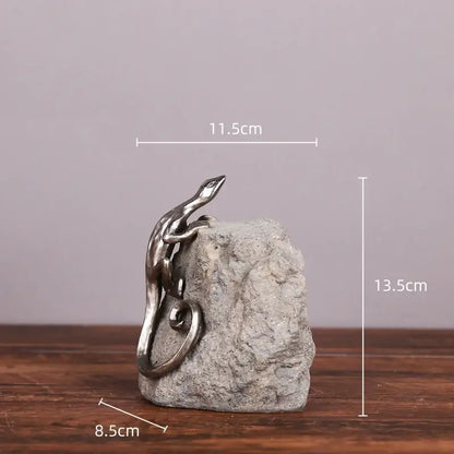 Silver gecko lizard resin figurine with metallic finish perched on textured gray stone base for living room decor