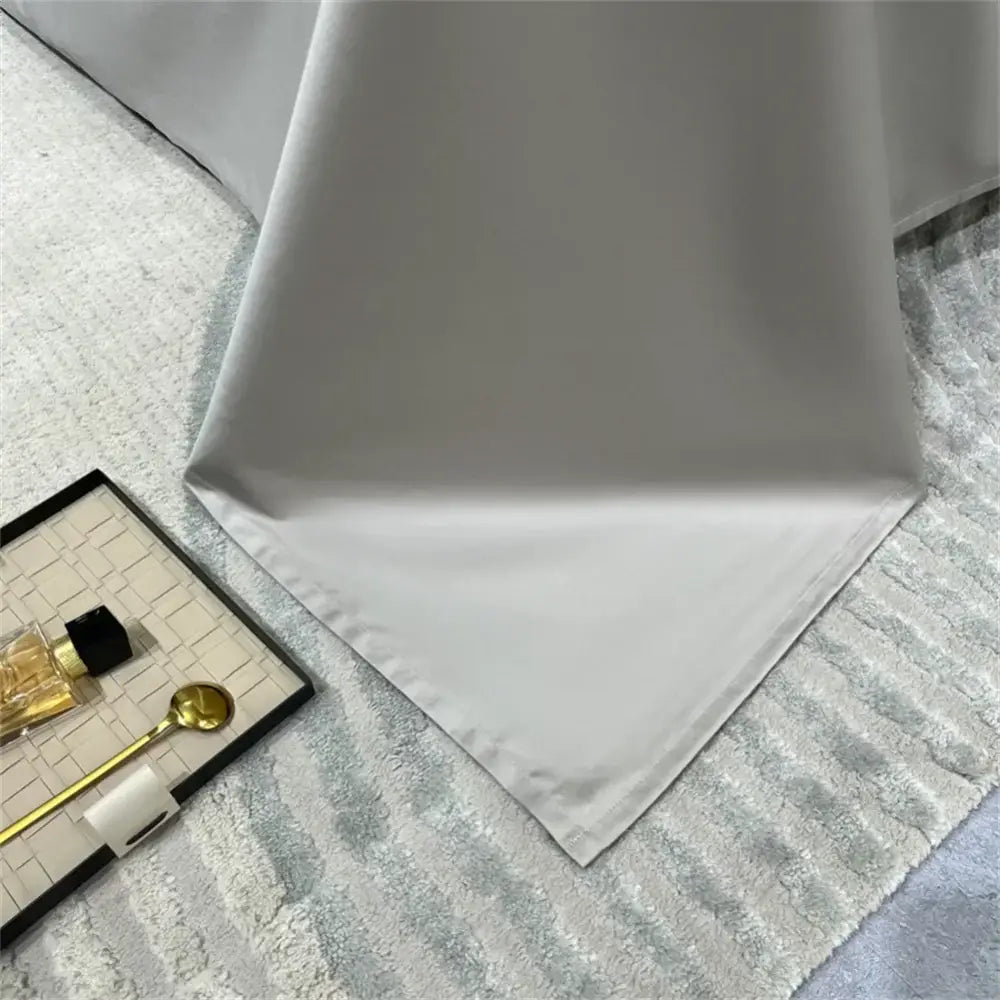 A smooth white satin tablecloth with subtle sheen and finished edges in a silver gray 1200tc embroidery egyptian cotton bedding set