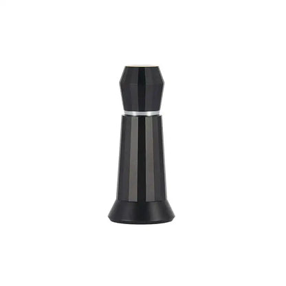 Black faceted glass perfume bottle with silver band next to silver hexagonal aluminum espresso distributor wdt tool kitchen accessory