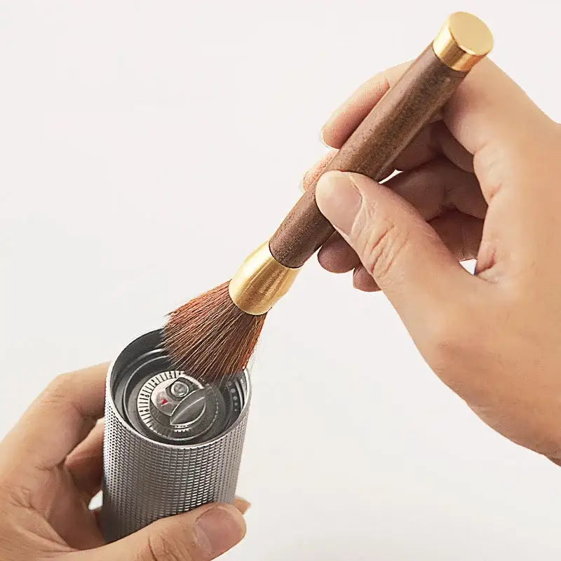 A sleek silver-textured cylindrical coffee grinder with textured grip and metallic top cap for coffee grinder cleaning