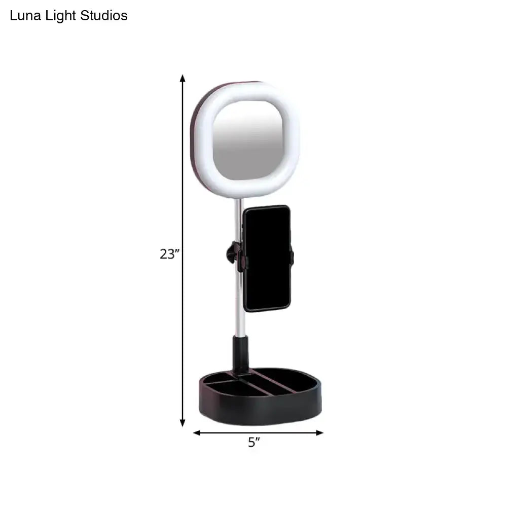 A sleek black and silver led mirror light with circular ring light and adjustable phone holder on slender stand
