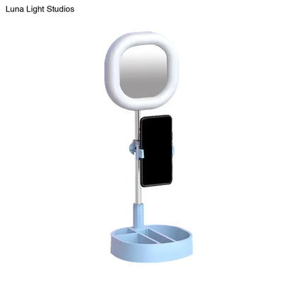Light blue led mirror light with circular ring and phone holder stand for bedroom vanity use
