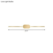 A sleek gold metallic wall mounted vanity sconce with a simple style and oval central accent for bedroom use