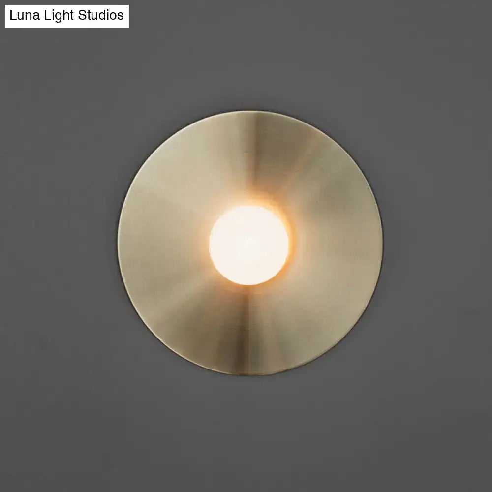 Simplicity brushed brass circular wall light fixture with a warm glowing center for bedroom wall lighting