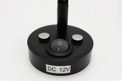 Black circular base with two silver buttons and power switch labeled dc 12v on the back of a sleek black led reading lamp