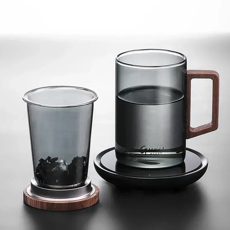 Sleek dark gray double walled glass tea cup with wooden handle lid and matching saucer for modern tea serving