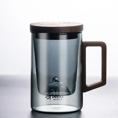 A sleek dark gray double walled glass tea cup with wooden lid and handle for kitchen use