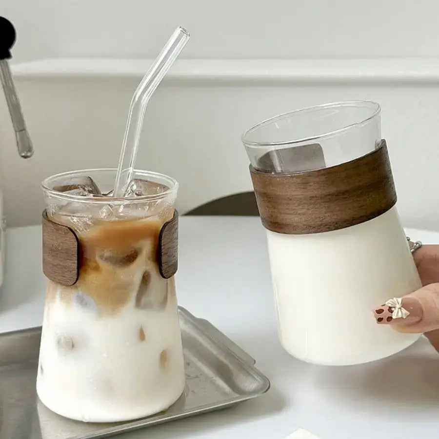Clear glass iced latte tumblers with sleek wooden bands one filled with iced coffee and one with milk for decorbites glass iced use