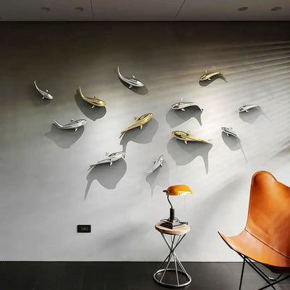 A sleek goldfish resin wall hanging featuring metallic silver and gold fish decorbites goldfish resin on gray wall