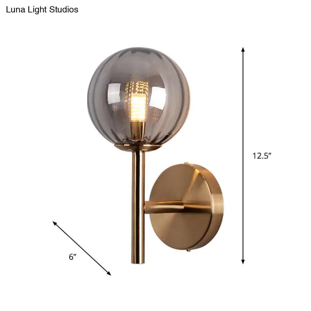 A modern round wall lighting with brushed brass finish and smoked glass globe bedside sconce light in red green amber