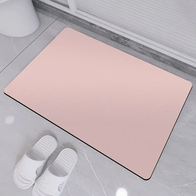 A sleek pink rubber bath rug with a smooth surface and black border for non-slip diatom ooze bath use