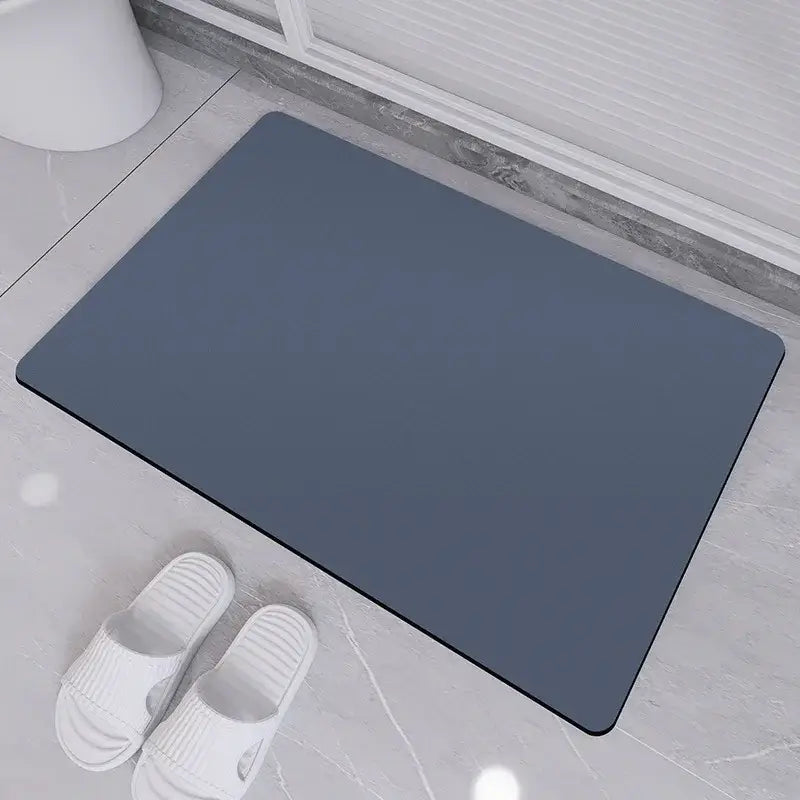 Dark gray rectangular diatom ooze bath rug with rounded corners placed on tiled floor for non-slip bathroom use