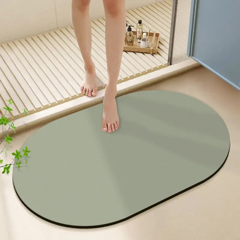 A sleek oval-shaped sage green diatom ooze bath rug with black border non-slip mat for bathroom use