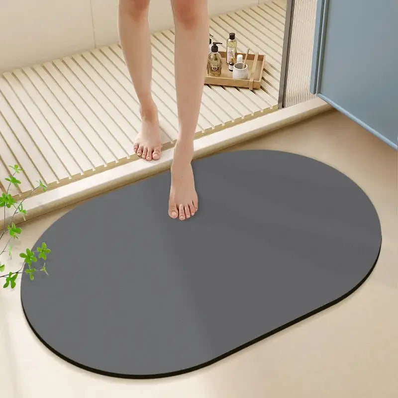 A sleek oval gray diatom ooze bath rug with smooth surface and black border for non-slip bathroom use