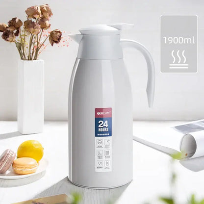 A sleek white 1900ml decorbites insulavacuum bottle with stainless steel body and ergonomic handle for kitchen use