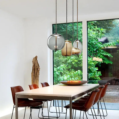 Sleek smoked glass led chandelier with frosted and amber glass led pendant lights above dining table