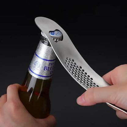 Silver metal bottle opener with perforated curved design and heart-shaped cutout for cap by decorbites garlic press