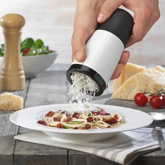 A sleek white and black handheld decorbites herb grinder chopper slicer grates parmesan over pasta for kitchen use