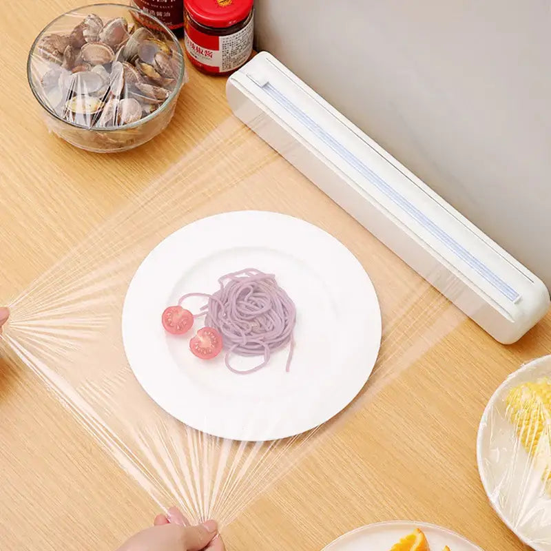 Sleek white plastic cling film dispenser cutter with clear cling film roll extending for kitchen food wrap use