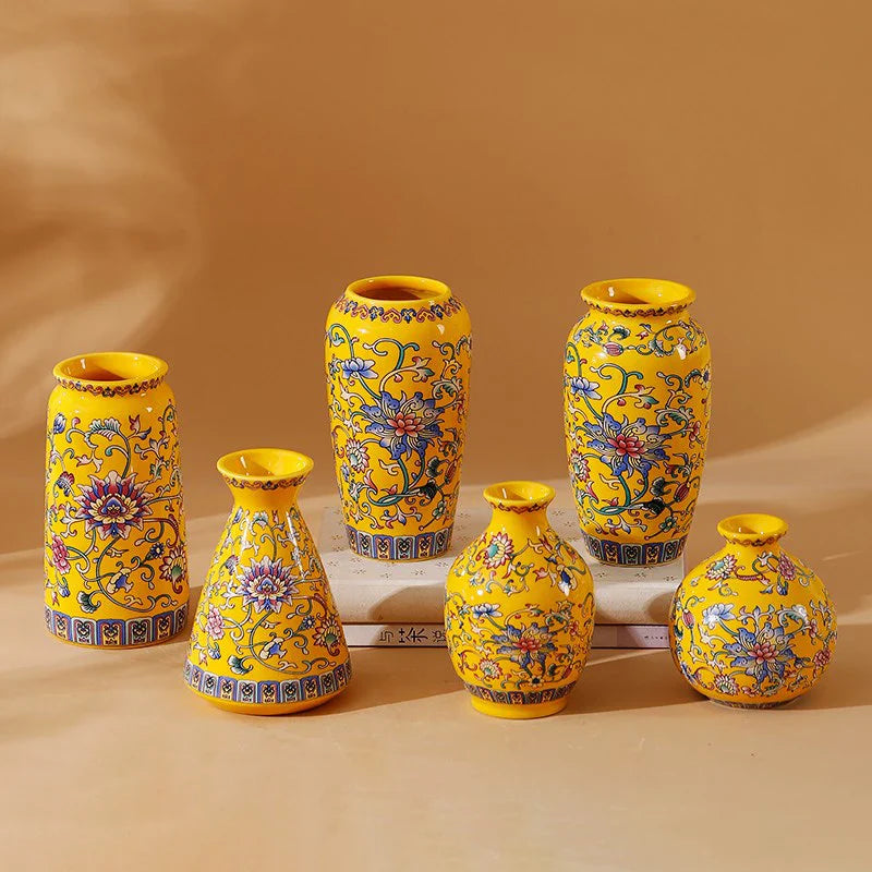 Set of six small vibrant yellow ceramic vases with blue and purple floral patterns handmade for home and office decor