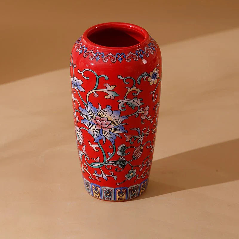 Small vibrant red ceramic vase with intricate blue pink and white floral patterns handmade vintage enamel glazed porcelain
