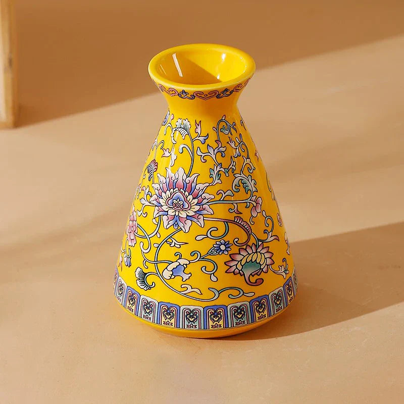 A small vibrant yellow ceramic vase with pink blue and green floral patterns enamel glazed porcelain for home office