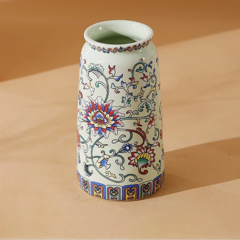A small white porcelain vase with colorful red blue and gold floral patterns for decorative home and office use