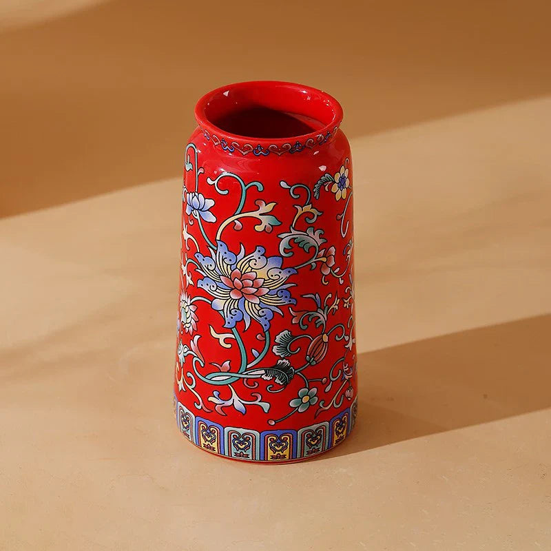 Small ceramic vase featuring vibrant red enamel glazed porcelain with intricate blue pink green floral vintage design