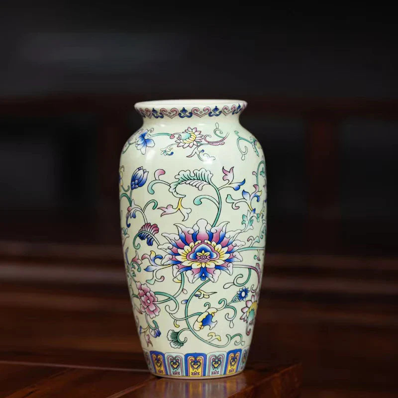 A delicate cream-colored small ceramic vase with colorful floral patterns in enamel glazed porcelain for home and office
