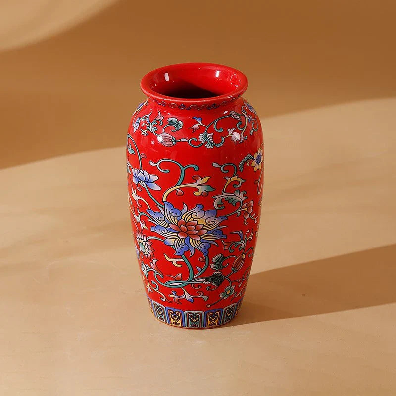 A vibrant red small ceramic vase with intricate blue white and gold floral patterns for office and home decor