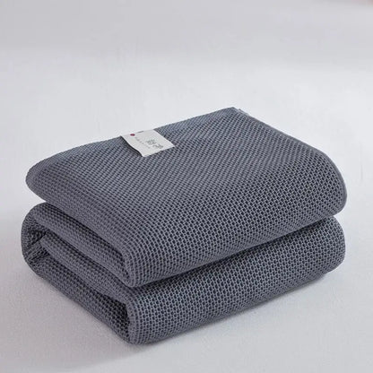 Stacked gray cotton honeycomb towel blanket with subtle texture and white tag for living room couch decorbites cotton honeycomb