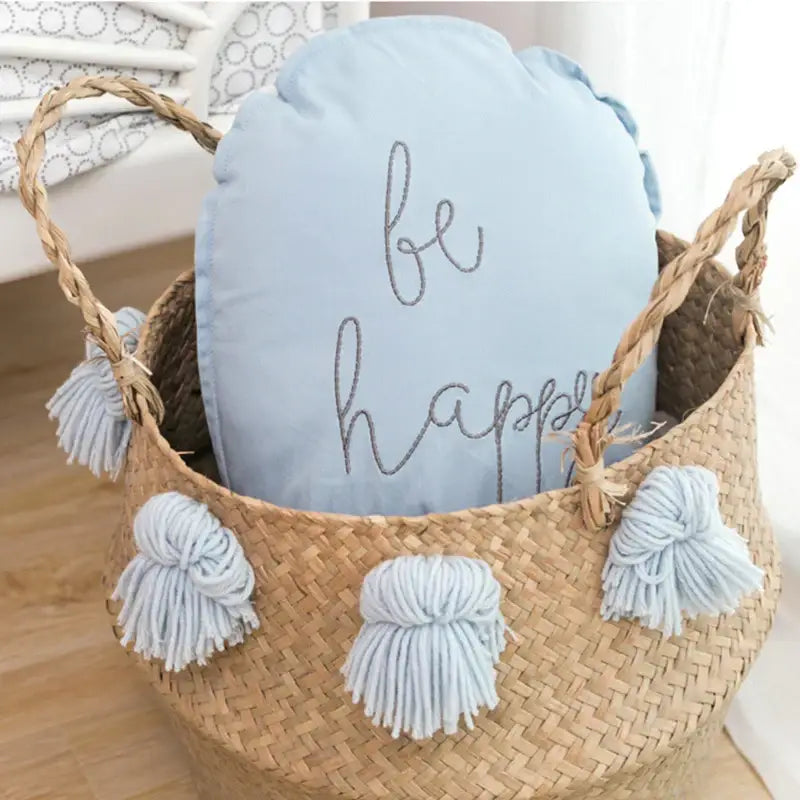 Light blue cotton balloon wall hanging cushion with be happy embroidered in silver inside woven wicker basket decor