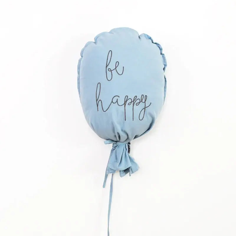 Light blue cotton balloon wall hanging cushion embroidered with be happy in black cursive for kids room decor