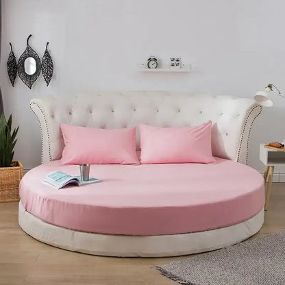 Round bed with tufted white headboard and pink bedding featuring soft dark gray decorbites cotton round bed sheet set