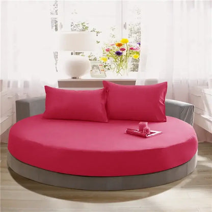 Vibrant fuchsia round bed with gray frame and matching pillows in soft dark gray cotton round bed sheet set by decorbites cotton round