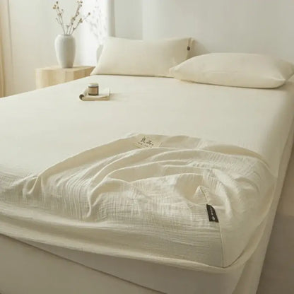 Soft light gray decorbites cotton fitted sheet with a cream-colored subtle textured weave and neatly folded edges