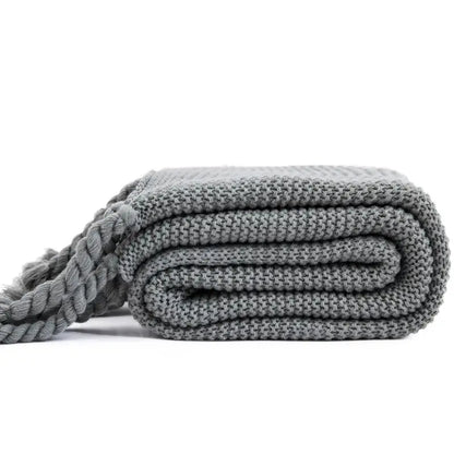 Soft medium-gray decorbites knit throw blanket with textured weave and thick braided tassel for cozy decor