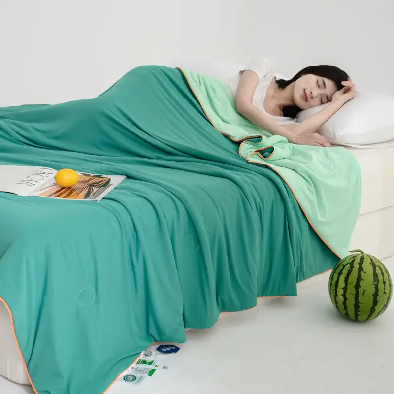 Soft teal and gold decorbites cool fibre summer quilt draped over a sleeping woman for a cool fibre summer bedroom blanket
