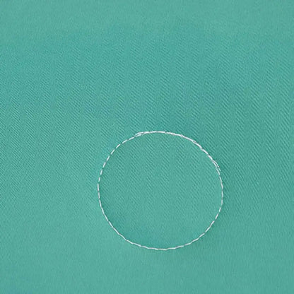 A white circular stitch detail on a soft teal and gold decorbites cool fibre summer quilt bedroom blanket
