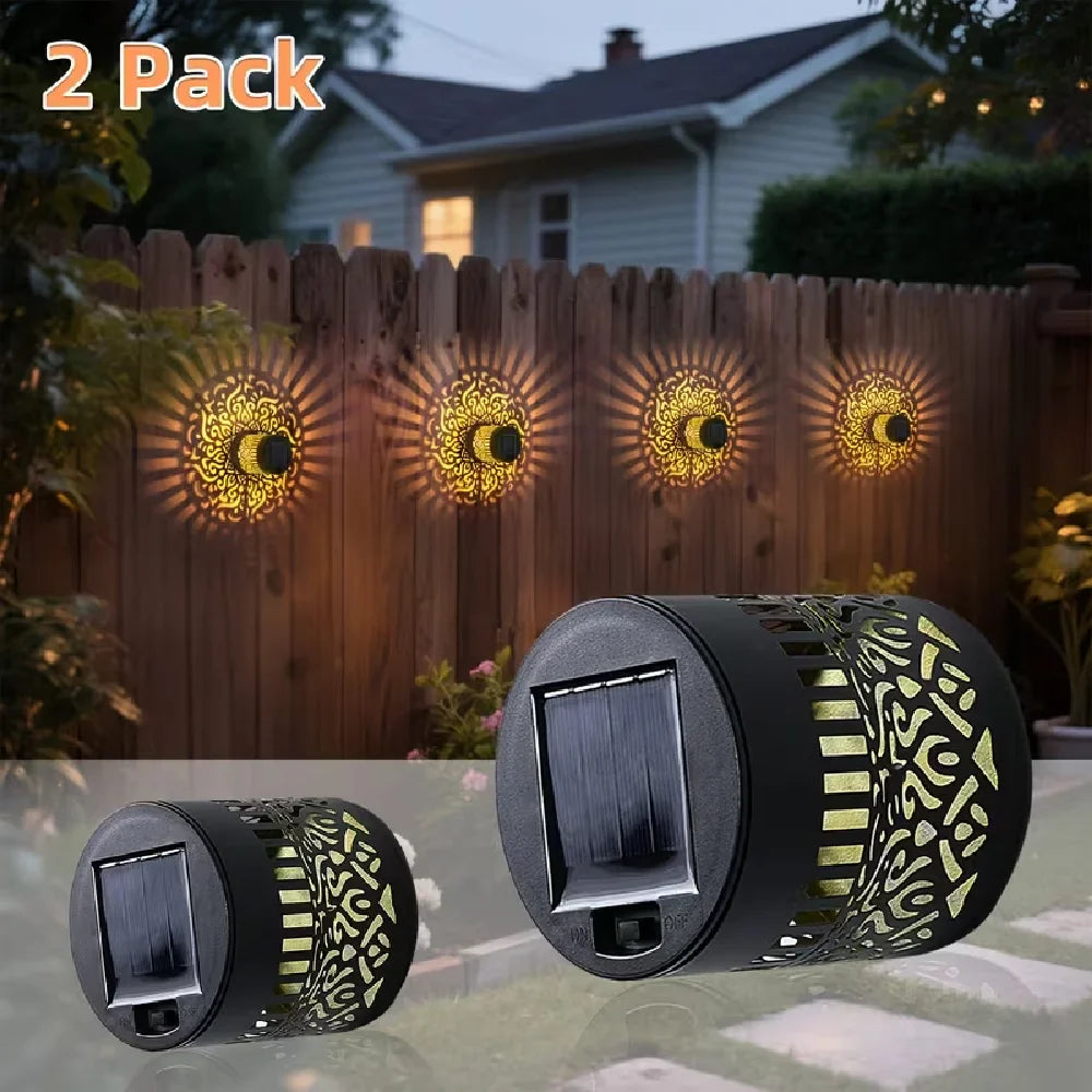 Black cylindrical solar mandala projection lights with gold cut-out patterns and solar panels for outdoor garden lighting