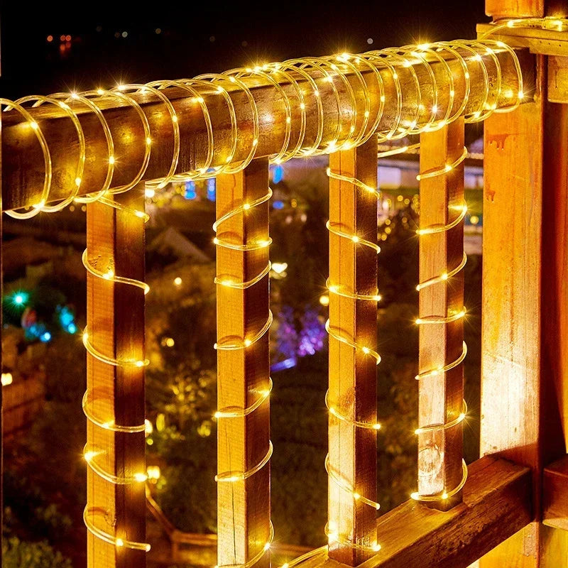 Warm golden solar led rope lights wrapped in clear flexible sheath around wooden railing posts for outdoor garden use