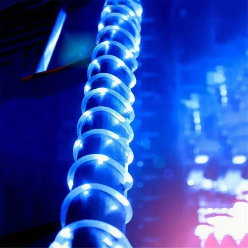 A glowing blue spiral solar led rope light strand designed for outdoor garden and deck waterproof lighting