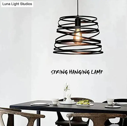 Black metal spiral spring suspension pendant light with warm glowing bulb for dining room use