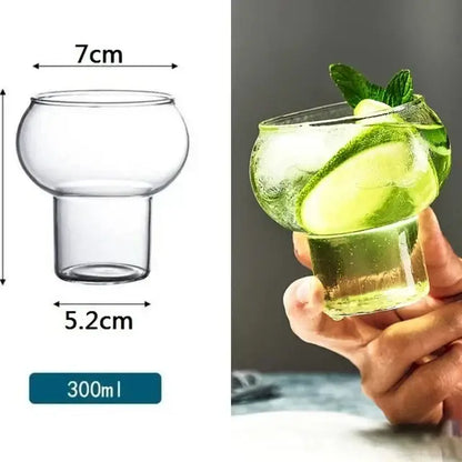 Clear glass cold brew coffee cup with rounded bowl and short stem holding ice and cucumber slices for brew coffee use