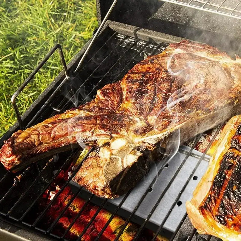 Stainless steel bbq smoker box with wood chips infuser enhances grilled t-bone steak with rich charred flavor